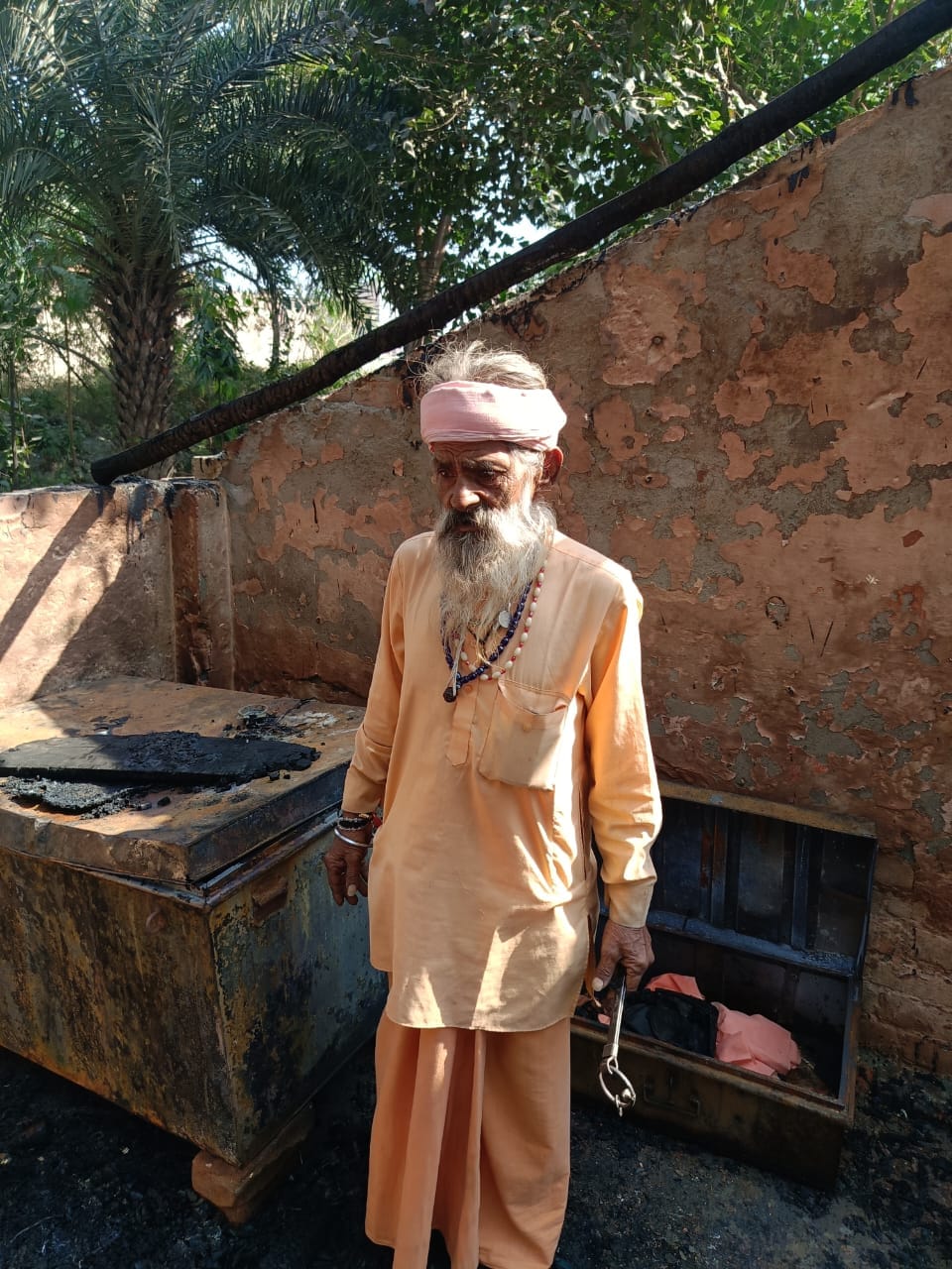 कुटिया में आग लगने से जले संदूक में रखे मृतक कर्मजीत के कपड़े। जीआरपी