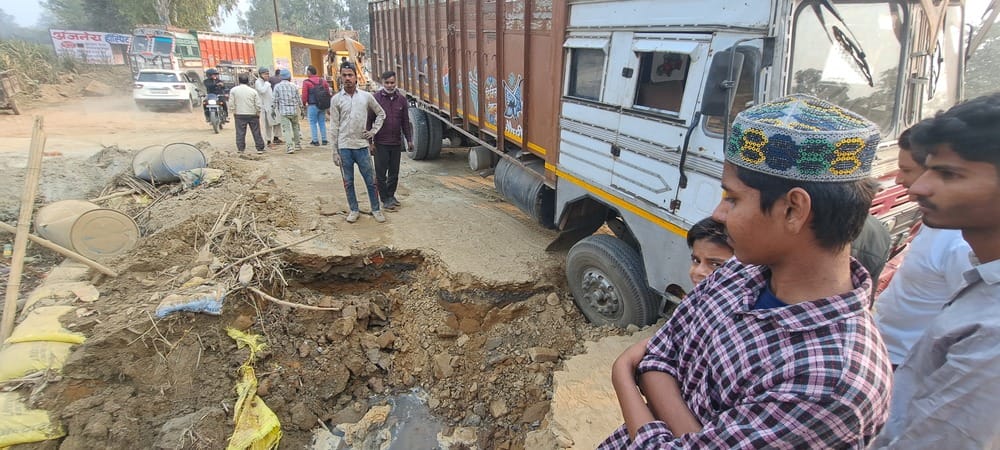 सरूरपुर। सरधना बिनौली रोड पर रजबहे का अस्थाई टूटने से से फंसे ट्रक। संवाद