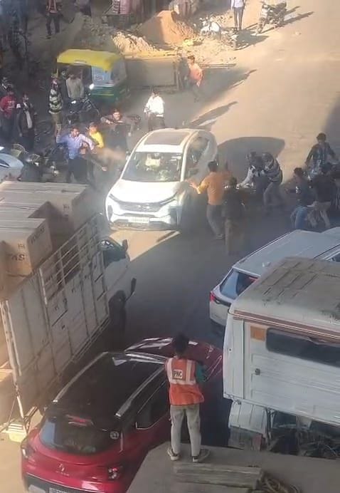 बंथरा कस्बे में हंगामा कर रहे कार सवार को रोकते स्थानीय लोग।