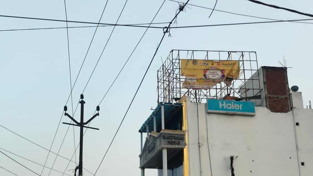 भवन की छत पर लगी बड़ी बड़ी होर्डिंग्स। संवाद