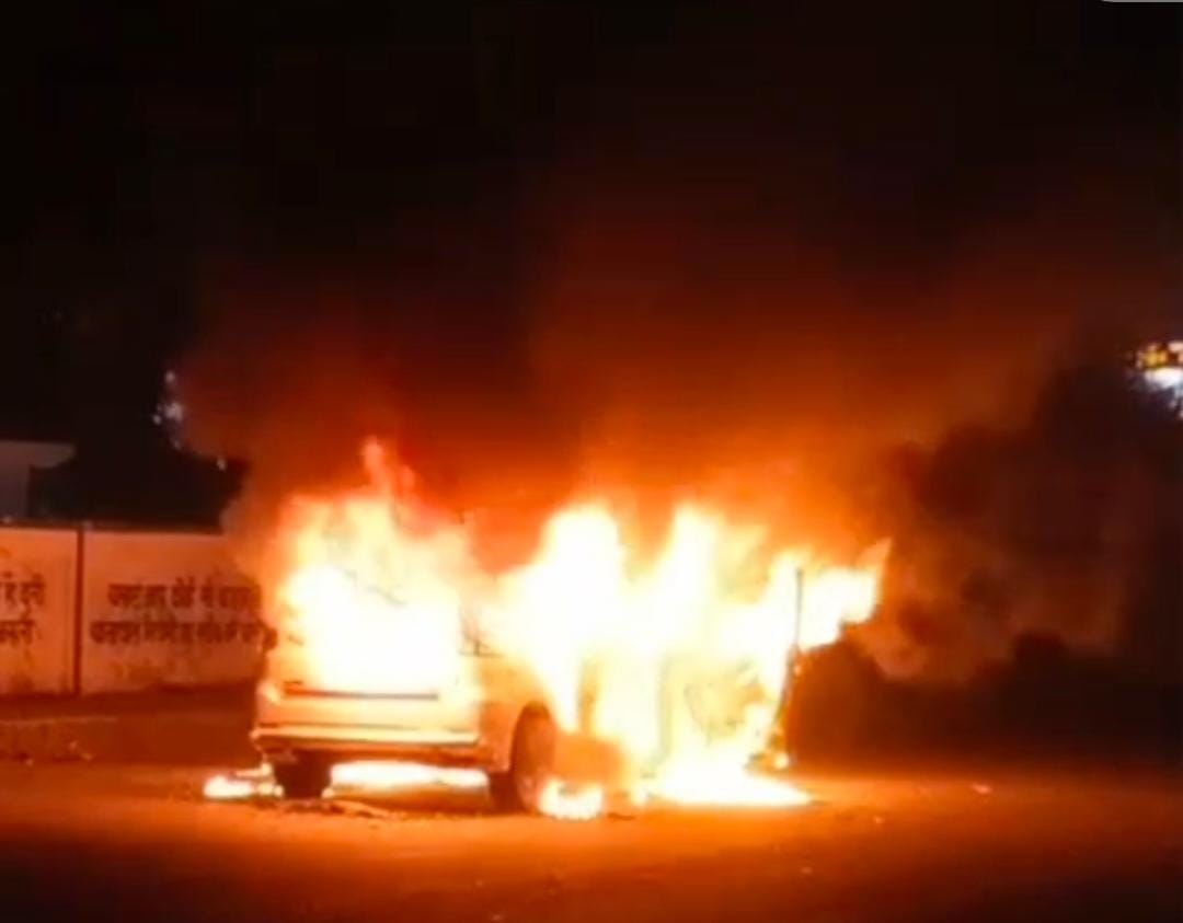 टेढ़ीपुलिया चौराहे पर कार से उठतीं आग की लपटें।