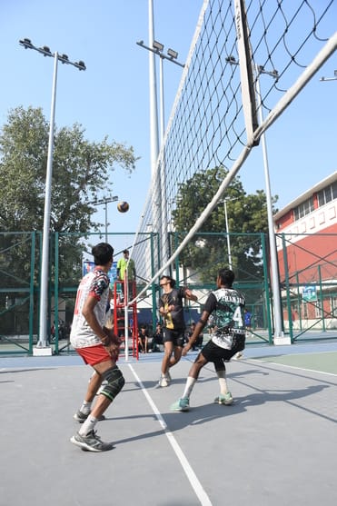 वाॅलीबॉल के मुकाबले के दाैरान अंक हासिल करने का प्रयास करते खिलाड़ी। 