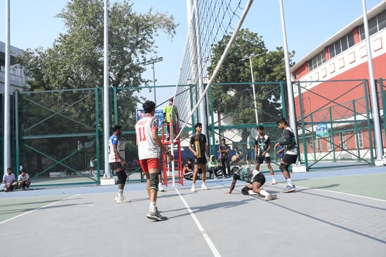 वाॅलीबॉल के मुकाबले के दाैरान अंक हासिल करने का प्रयास करते खिलाड़ी। 