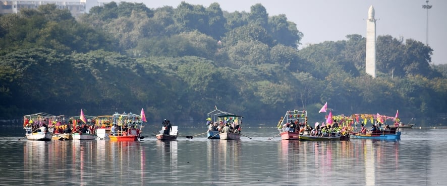 गोमती नदी में निकाली नौकाओं की भव्य शोभायात्रा में शामिल कलाकार। -अमर उजाला