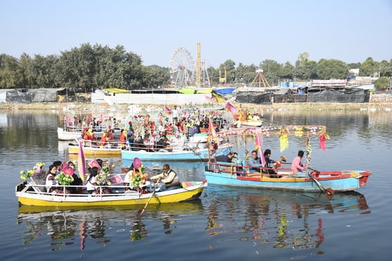 गोमती नदी में निकाली नौकाओं की भव्य शोभायात्रा में शामिल कलाकार। -अमर उजाला