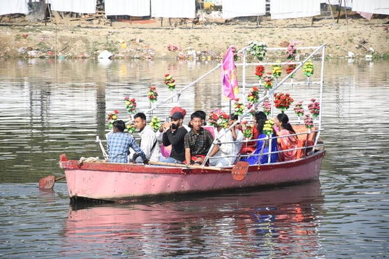 गोमती नदी में निकाली नौकाओं की भव्य शोभायात्रा में शामिल कलाकार। -अमर उजाला