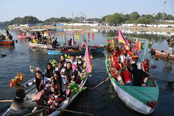 गोमती नदी में निकाली नौकाओं की भव्य शोभायात्रा में शामिल कलाकार। -अमर उजाला