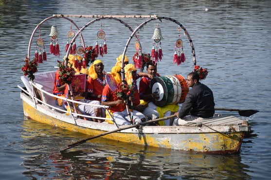 गोमती नदी में निकाली नौकाओं की भव्य शोभायात्रा में शामिल कलाकार। -अमर उजाला