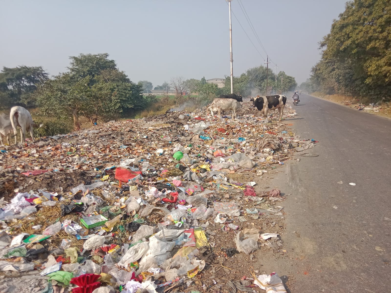 रसूलपुर बिलहरी गांव के पास डंप शहर से निकलने वाले कूड़ा में लगी आग से उठता धुआं। संवाद