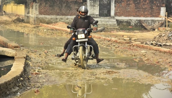 कानपुर रोड स्थित तपोवननगर में काली मंदिर के पास जर्जर सड़क से गुजरते लोग। कानपुर रोड स्थित तपोवननगर में काली मंदिर के पास जर्जर सड़क से गुजरते लोग।