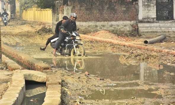 कानपुर रोड स्थित तपोवननगर में काली मंदिर के पास जर्जर सड़क से गुजरते लोग। कानपुर रोड स्थित तपोवननगर में काली मंदिर के पास जर्जर सड़क से गुजरते लोग।