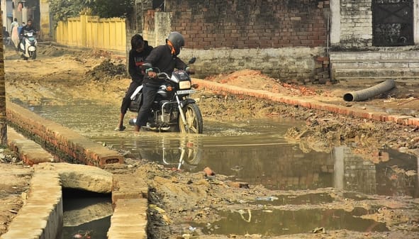 कानपुर रोड स्थित तपोवननगर में काली मंदिर के पास जर्जर सड़क से गुजरते लोग। कानपुर रोड स्थित तपोवननगर में काली मंदिर के पास जर्जर सड़क से गुजरते लोग।