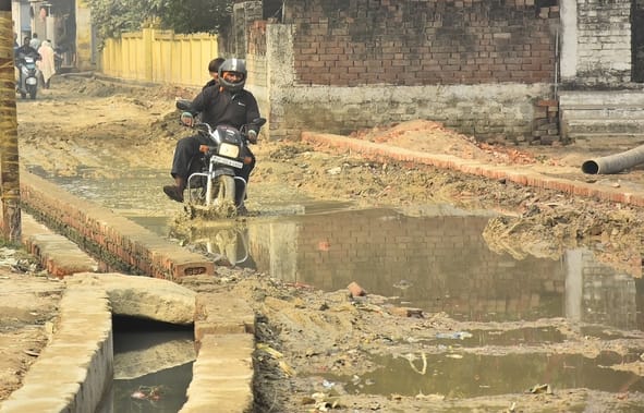 कानपुर रोड स्थित तपोवननगर में काली मंदिर के पास जर्जर सड़क से गुजरते लोग। कानपुर रोड स्थित तपोवननगर में काली मंदिर के पास जर्जर सड़क से गुजरते लोग।