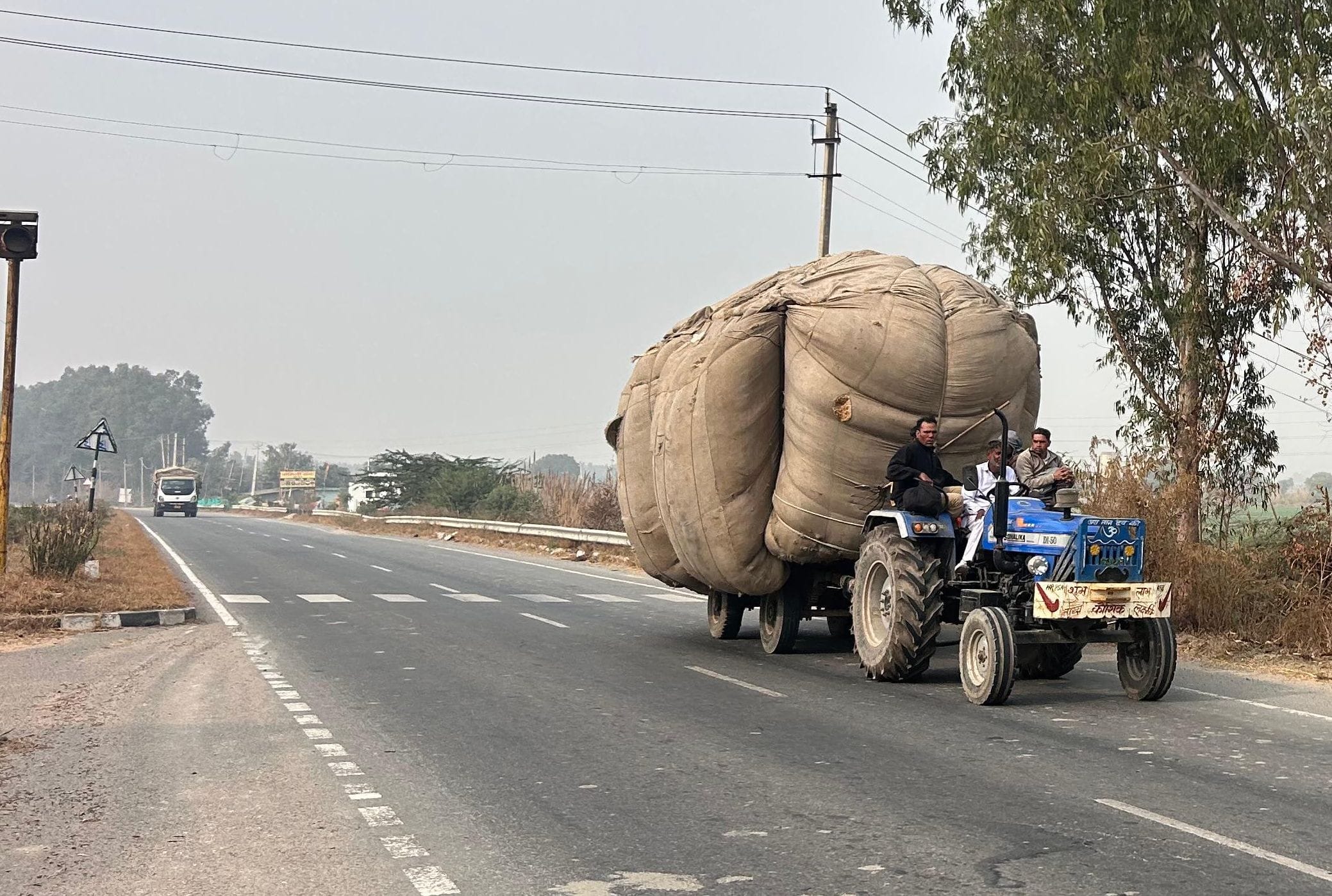 02...रोहतक के पानीपत राष्ट्रीय राजमार्ग पर ओवरलोड होकर कारों के बीच चलता ट्रैक्टर-ट्राला। संवाद