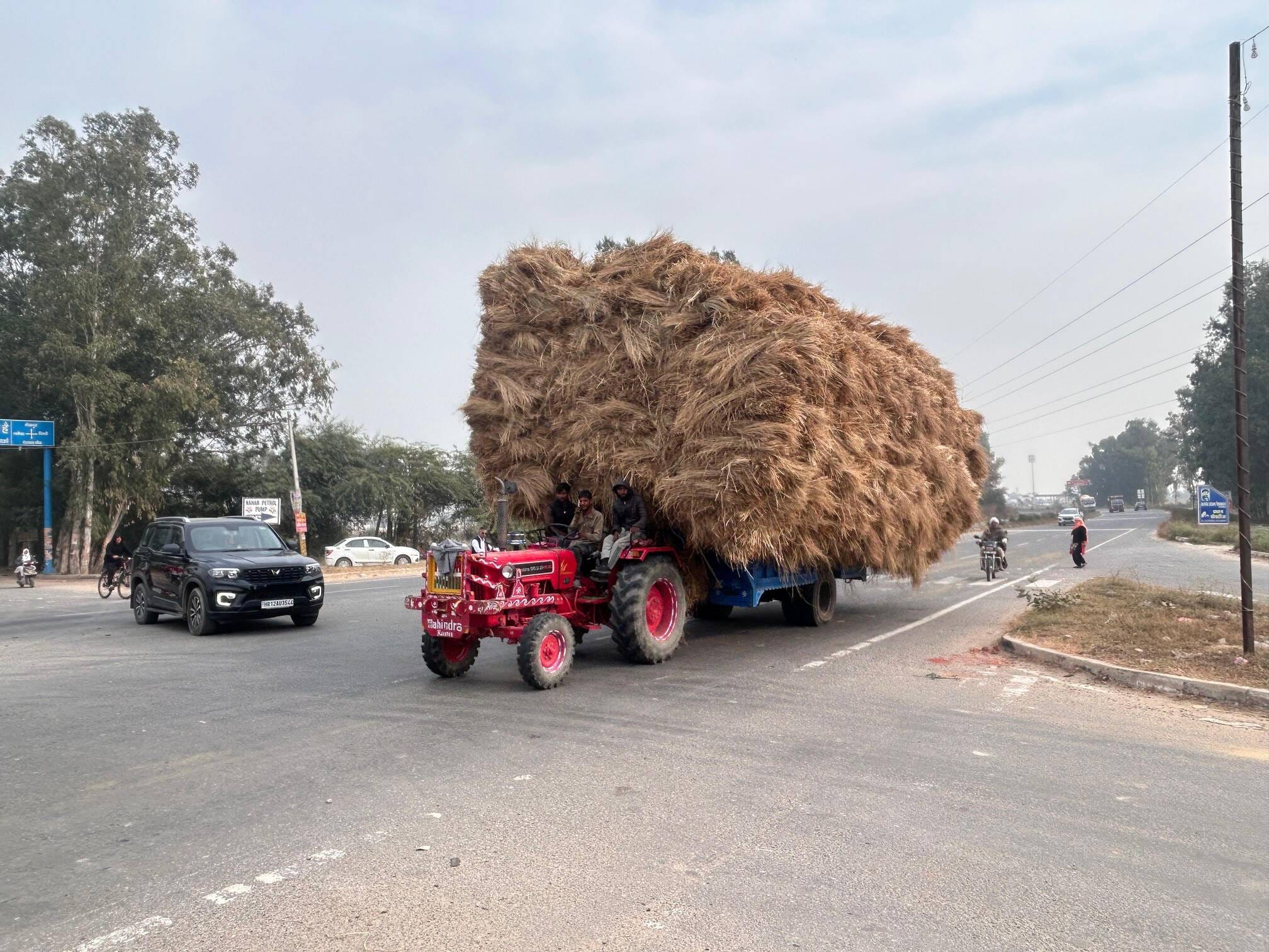 02...रोहतक के पानीपत राष्ट्रीय राजमार्ग पर ओवरलोड होकर कारों के बीच चलता ट्रैक्टर-ट्राला। संवाद