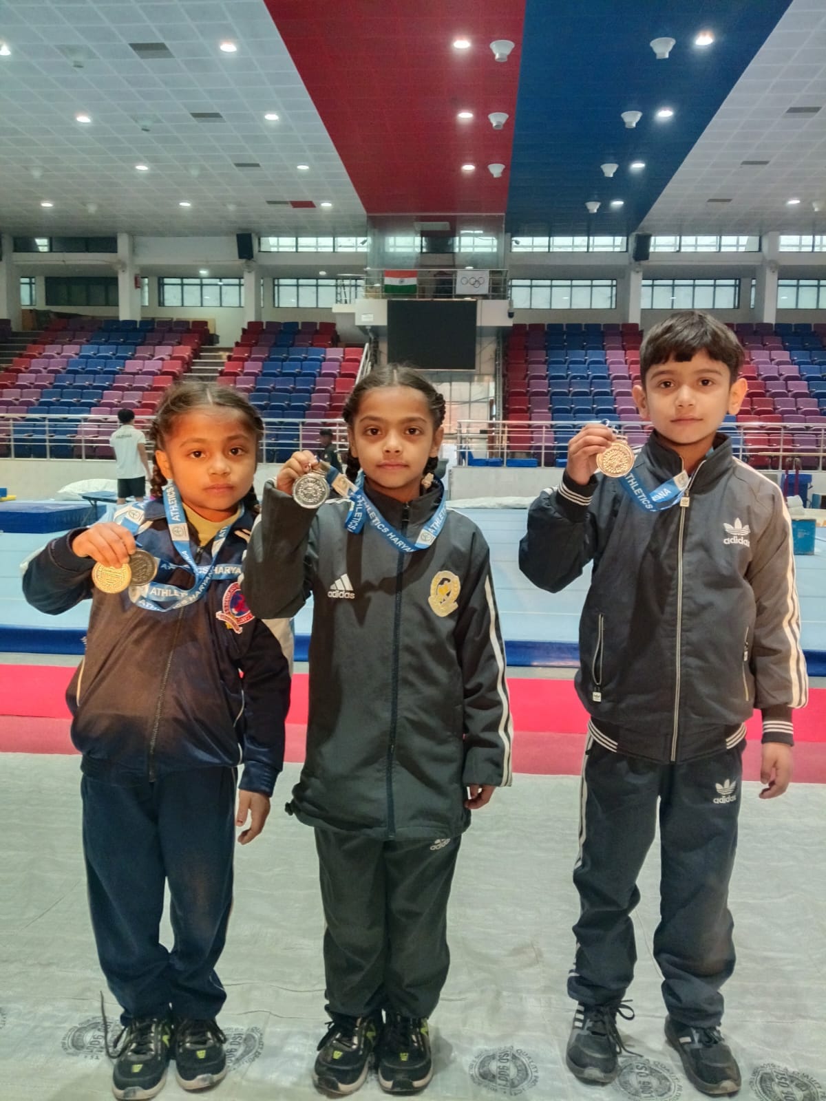 अंबाला कैंट की जुड़वा बहनें प्रभकीरत, प्रभसीरत व एक अन्य छात्र चित्रांश जीते हुए पदक दिखाते हुए