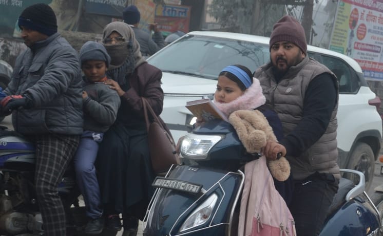 बिजनौर में कड़ाके की ठंड में बच्चों को गर्म कपड़ों में लपेटकर स्कूल छोड़ने जाते अभिभावक। संवाद