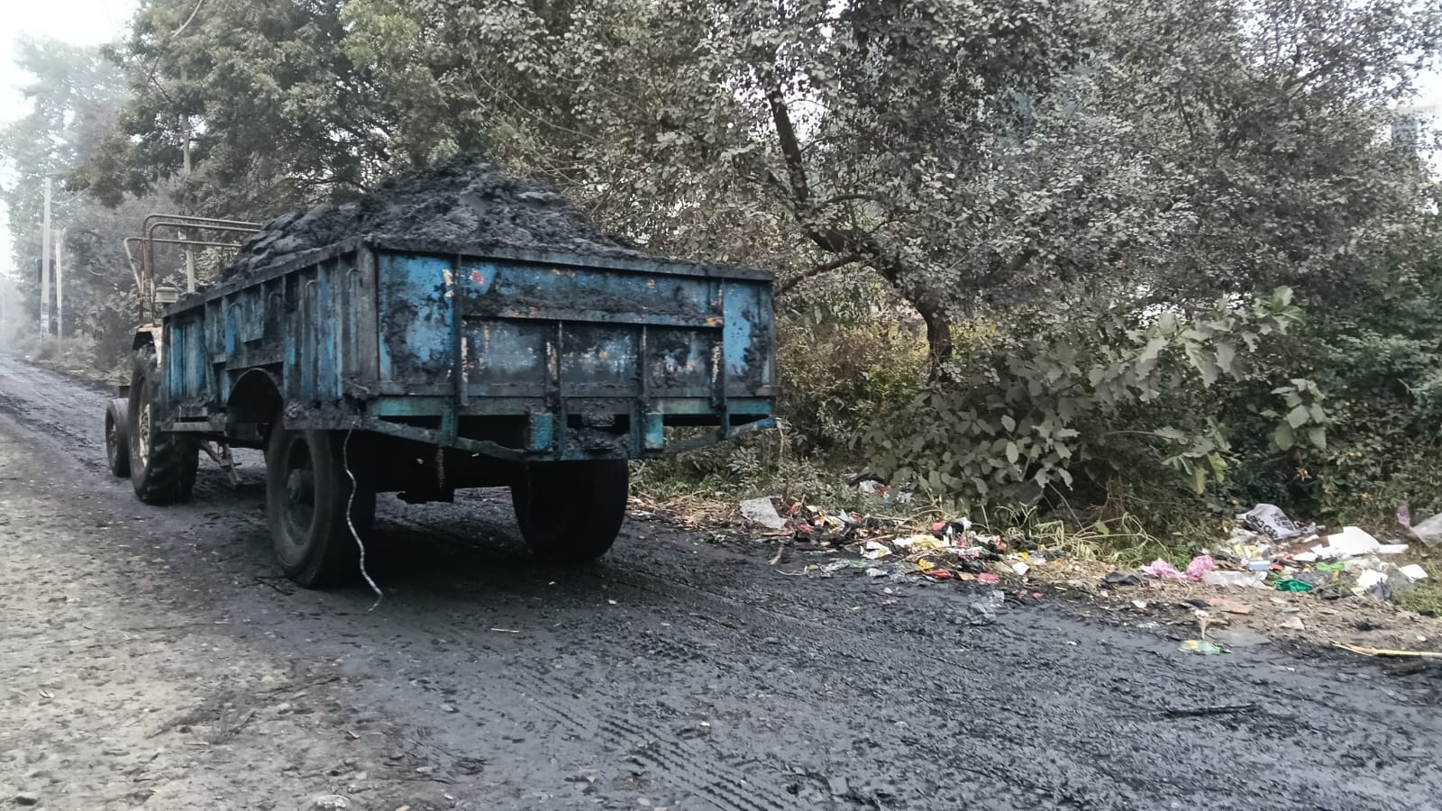 चीनी मिल की राख की वजह से माधोटांडा रेलवे क्रासिंग के पास सड़क पर कालिख और कीचड़ संवाद