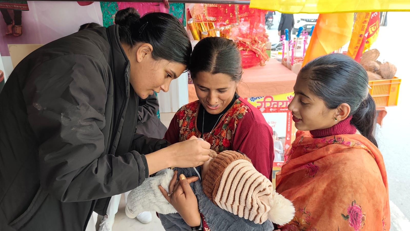 मेडिकल कॉलेज में पोलियो बूथ पर उपायुक्त प्रियंका वर्मा की बेटी को दवा पिलातीं स्वास्थ्य कर्मी। 