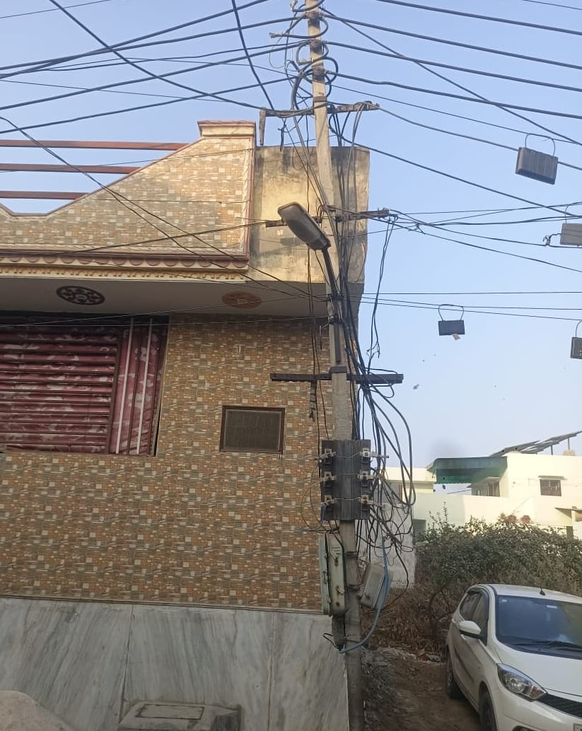 2.. कन्हेली रोड के नजदीक आंबेडकर कॉलोनी में खंभे पर लगा खुला मीटर व लटकी तार। संवाद