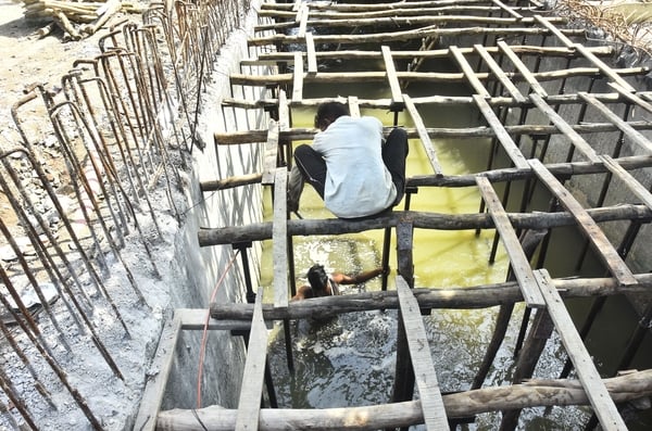 बिना सुरक्षा उपकरणों के नालों की स्लैब डालने का काम करते मजदूर।