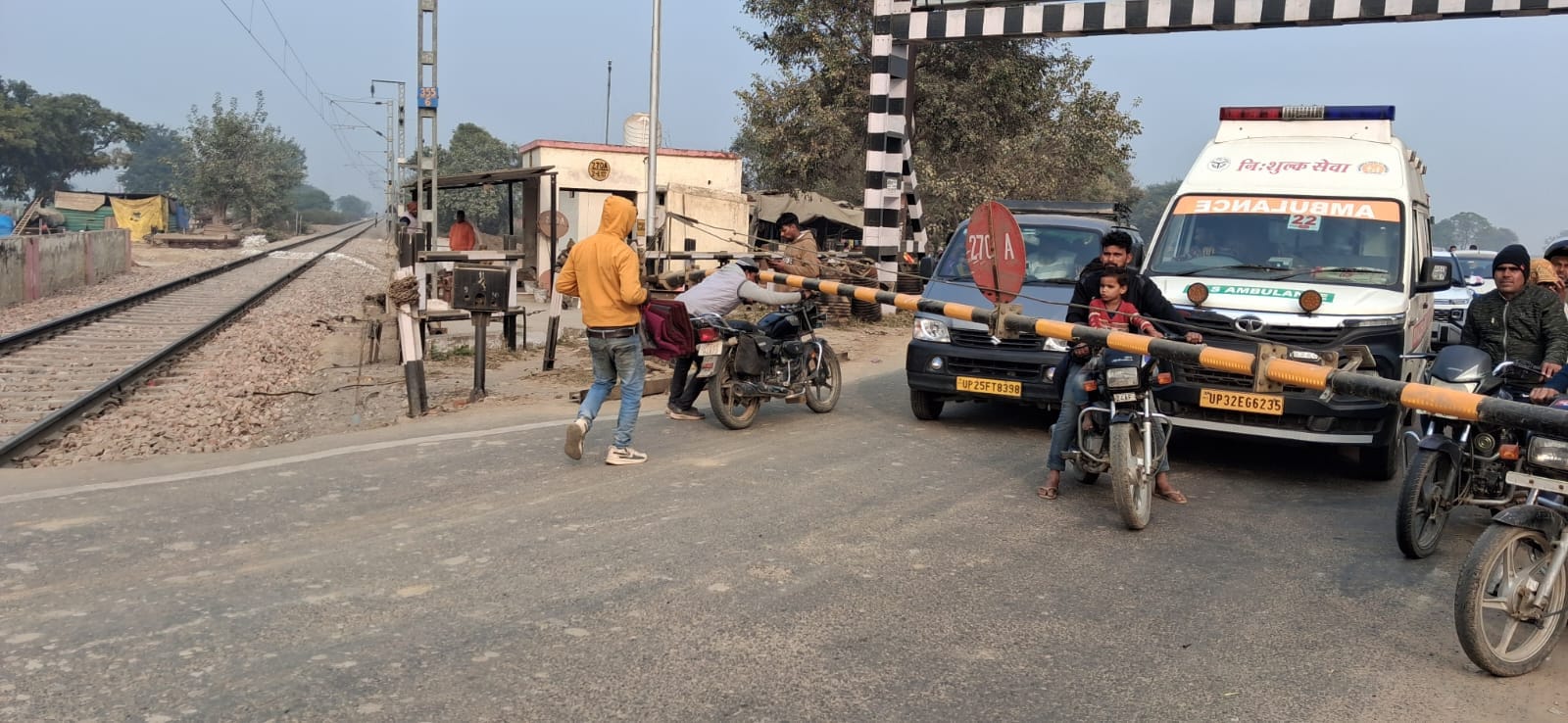 उझानी के पास रेलवे क्रासिंग बंद होने के बाद भी गेट पार करता बाइक सवार। संवाद