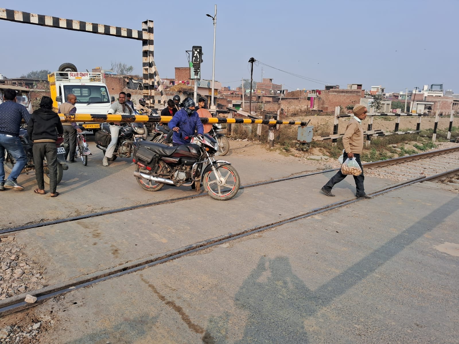 उझानी के पास रेलवे क्रासिंग बंद होने के बाद भी गेट पार करता बाइक सवार। संवाद