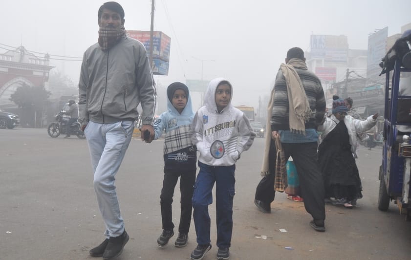 सुबह के समय तहसील चौराहे पर कोहरे में वाहनों की लाइट जलाकर सड़क पर जाते वाहन चालक। संवाद