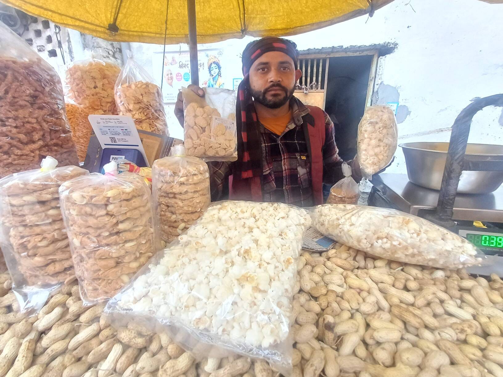 कारोबारी राजेंद्र कुमार ग्राहकों को मूंगफली देते हुए। संवाद