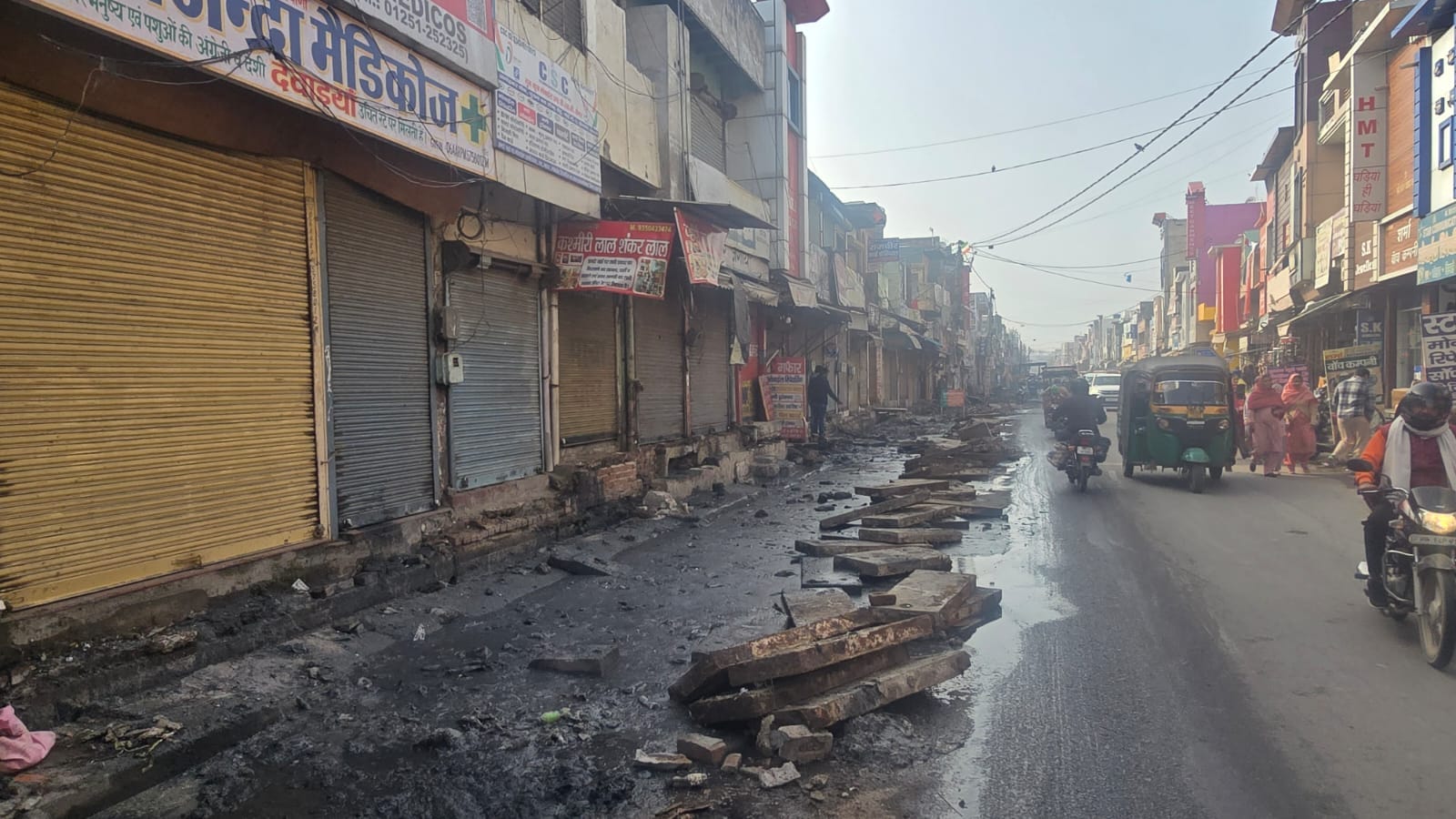 07jjrp13- झज्जर। आंबेडकर चौक पर मजदूर बुलाकर दुकान के सामने सफाई कराते दुकानदार। संवाद