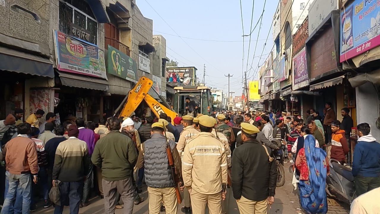 कार्रवाई के बाद मलबा हटाते दुकानदार, संवाद