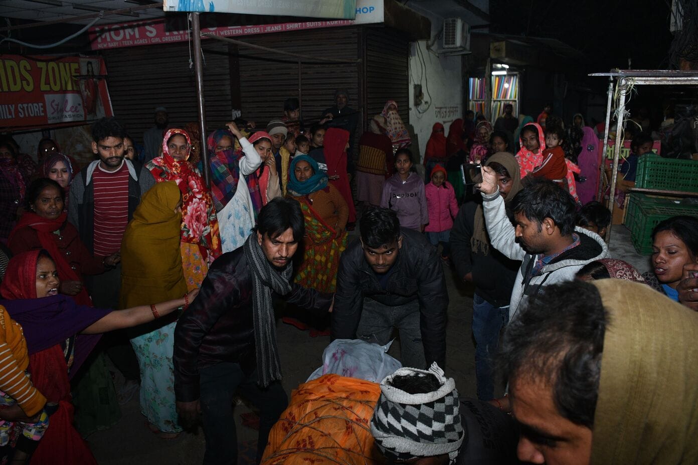 शटरिंग कारीगर के शव के साथ महानगर में प्रदर्शन करते परिजन। 