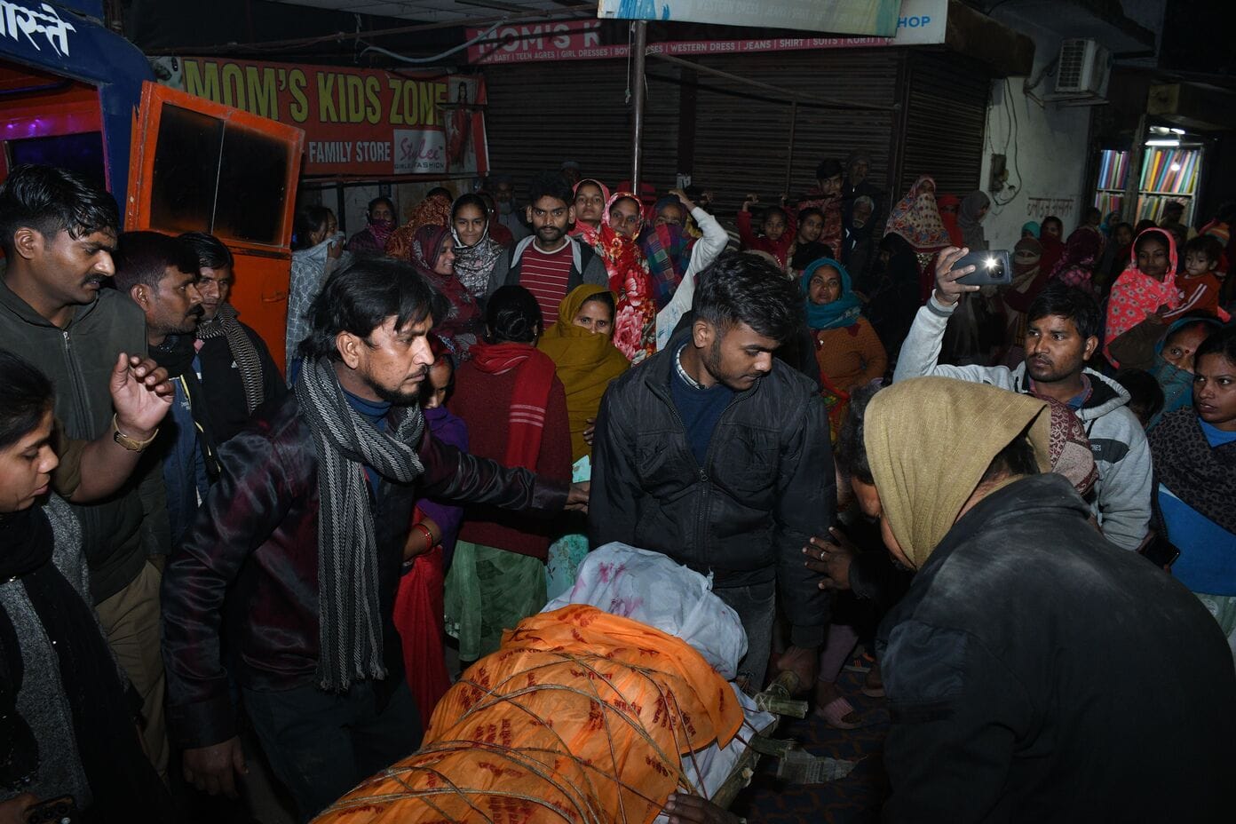 शटरिंग कारीगर के शव के साथ महानगर में प्रदर्शन करते परिजन। 