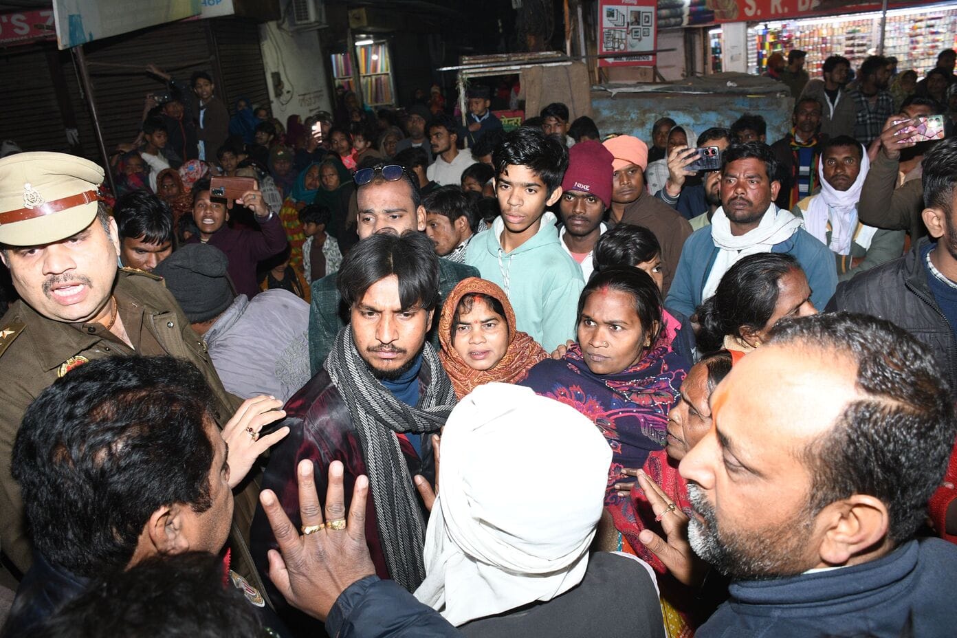 शटरिंग कारीगर के शव के साथ महानगर में प्रदर्शन करते परिजन। 