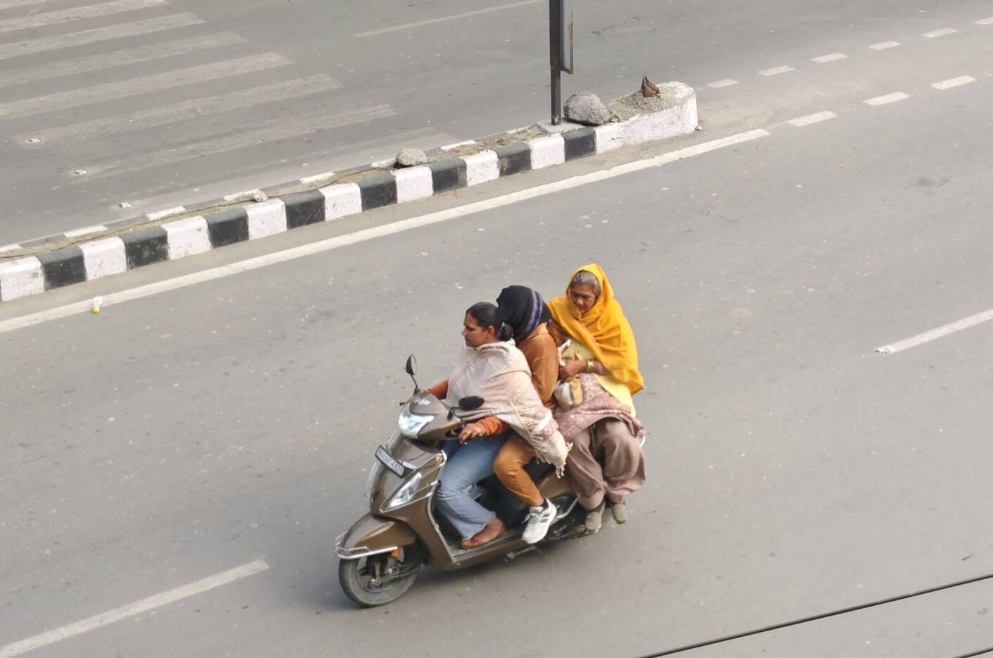 करनाल रोड पर हाथ में हेलमेट लेकर गुजरता बाइक सवार। संवाद