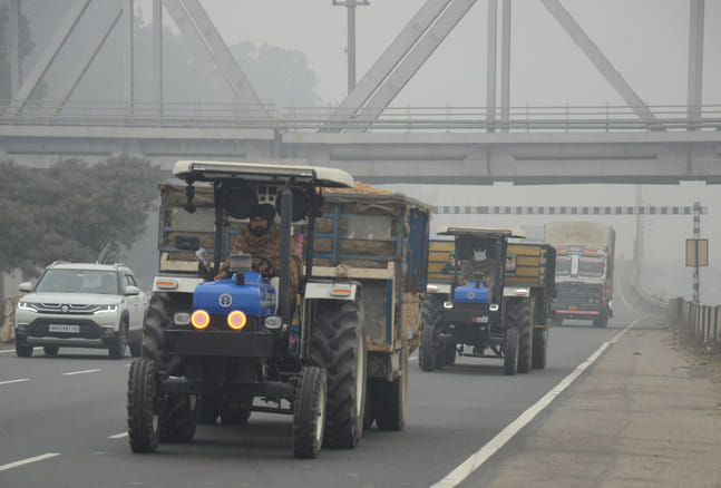 अंबाला में कोहरे और कडाके की ठंड में अपना बचाव करते हुए राजमार्ग से गुजरता बाइक सवार। संवाद