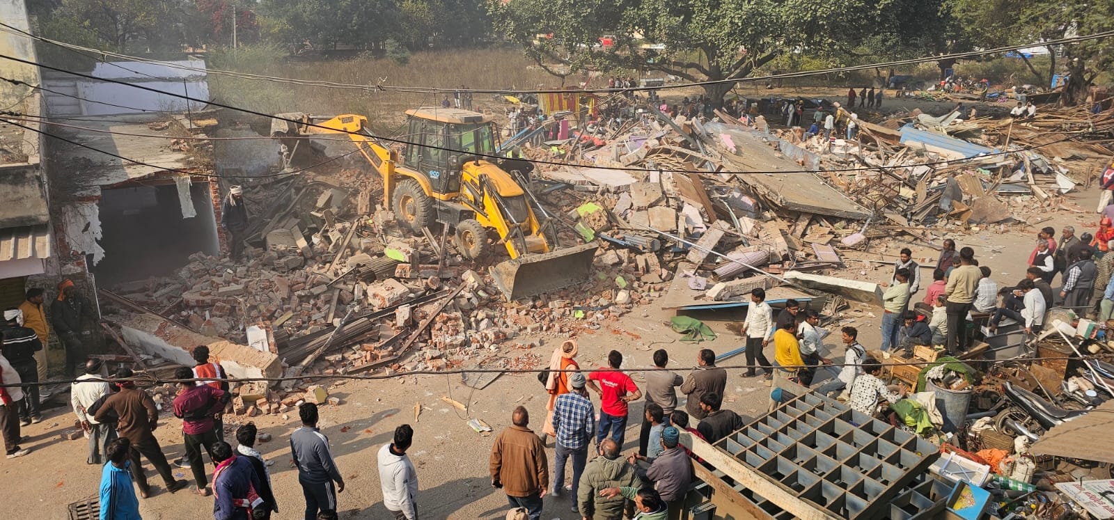 ध्वस्तीकरण कार्रवाई के दौरान दुकानों को खाली कर सामान ले जाते लोग। संवाद ध्वस्तीकरण कार्रवाई के दौरान दुकानों को खाली कर सामान ले जाते लोग। संवाद