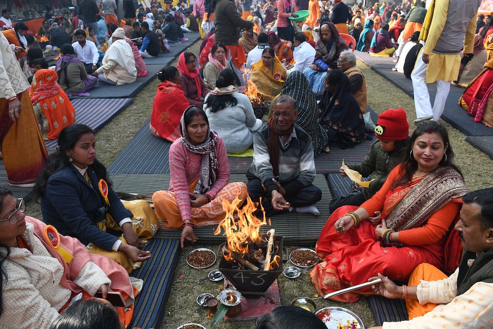 जानकीपुरम स्थित मदर्स प्राइड स्कूल के प्रांगण में कार्यक्रम के दौरान आहुति देते लोग।