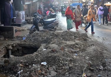 मोहल्ला तारीन टिकली मार्ग पर उखड़ी सड़क से निकलते लोग। संवाद