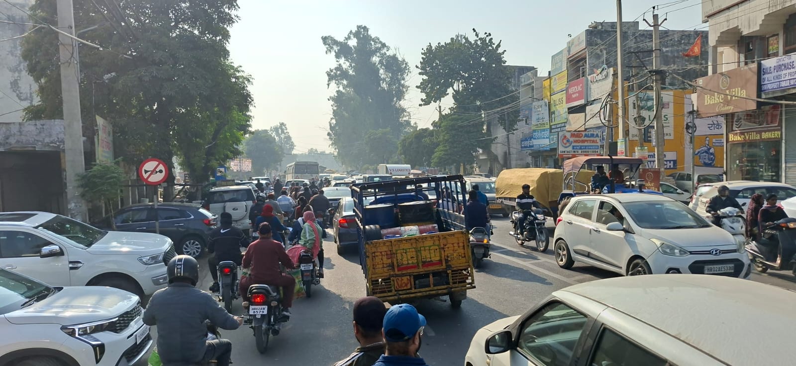 धूप में शहर के नेहरू पार्क में बच्चे को खिलाती युवती। संवाद