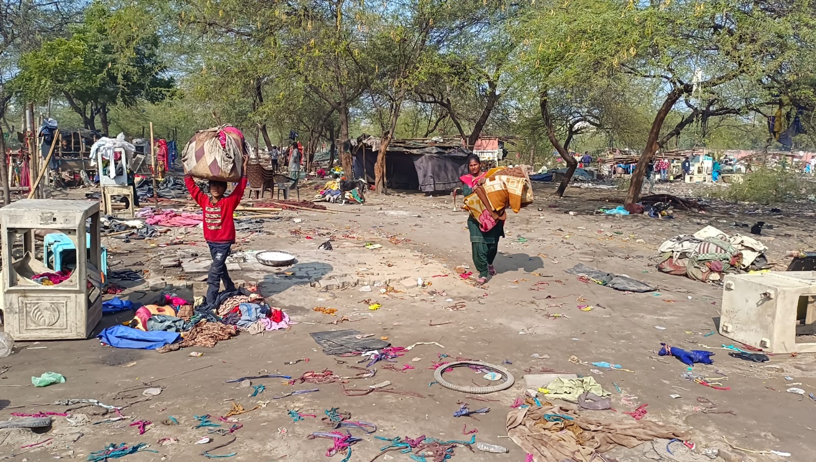झुग्गियां हटाने के बाद जमीन को समतल करती जेसीबी। 