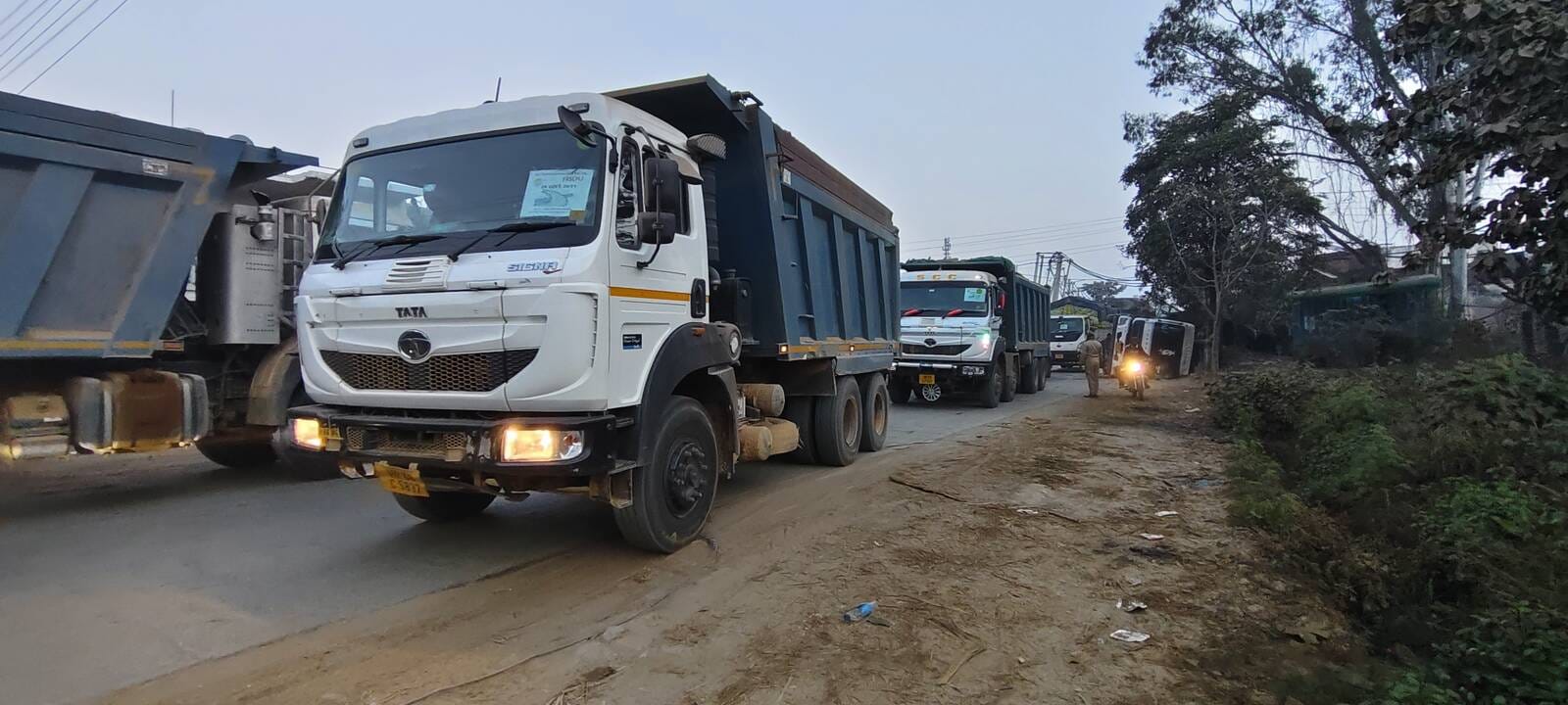 सड़क के किनारे पलटा ट्राला व गिरे बिजली के खंभे। संवाद सड़क के किनारे पलटा ट्राला व गिरे बिजली के खंभे। संवाद