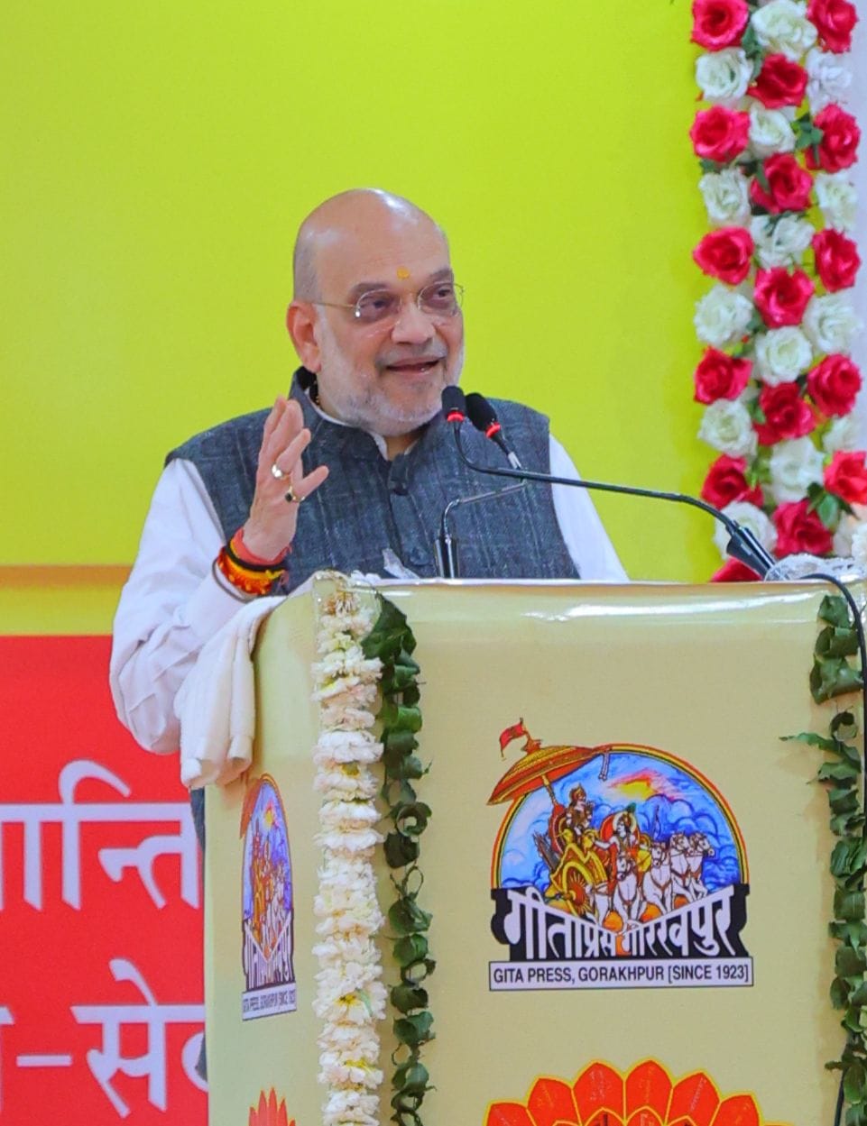 वेद निकेतन हैलीपेड पर केंद्रीय गृह मंत्री को पुष्पगुच्छ भेंट कर स्वागत करते मुख्यमंत्री। स्रोत 