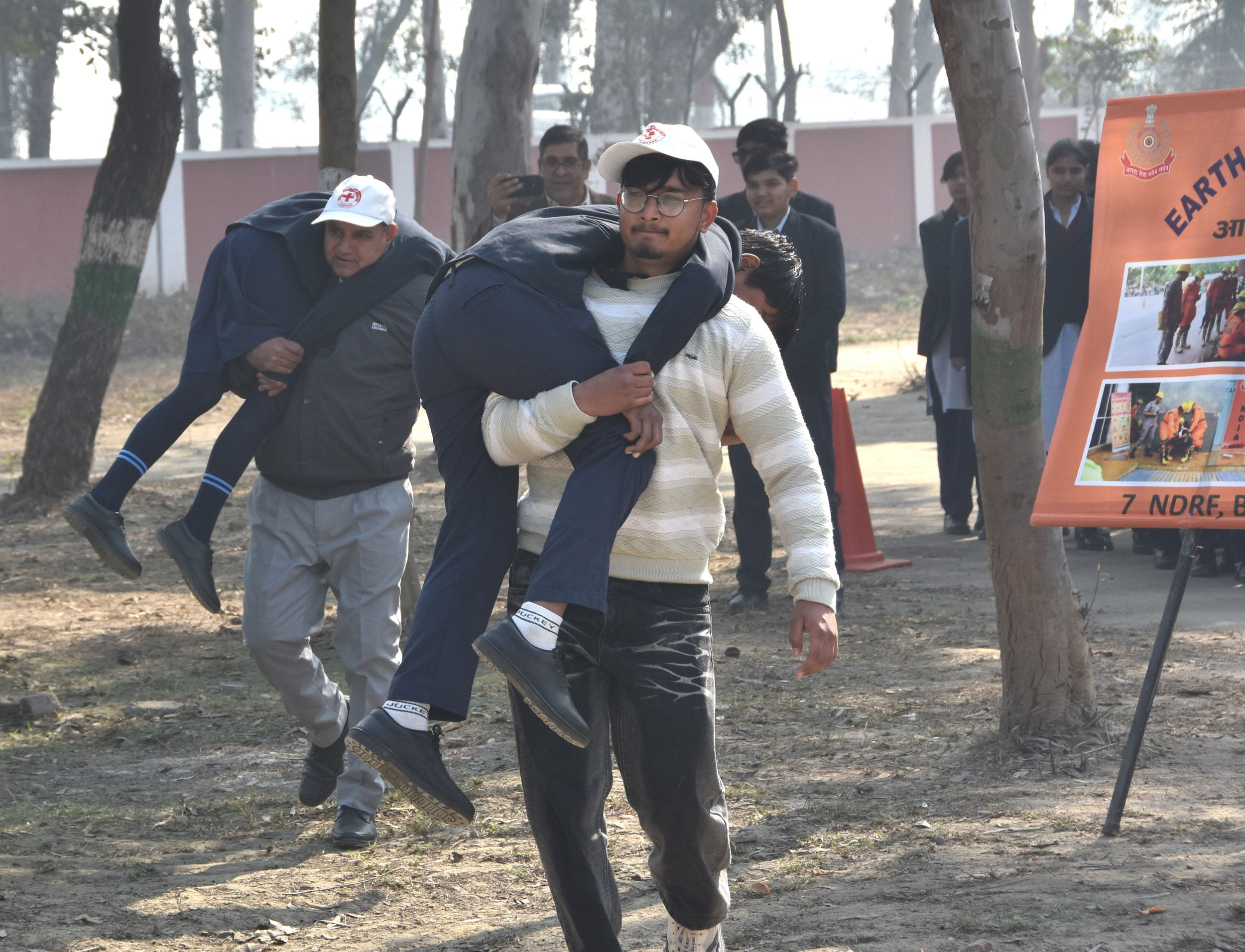 भवन के अंदर से बच्चों को निकालते टीम के सदस्य। भवन के अंदर से बच्चों को निकालते टीम के सदस्य।