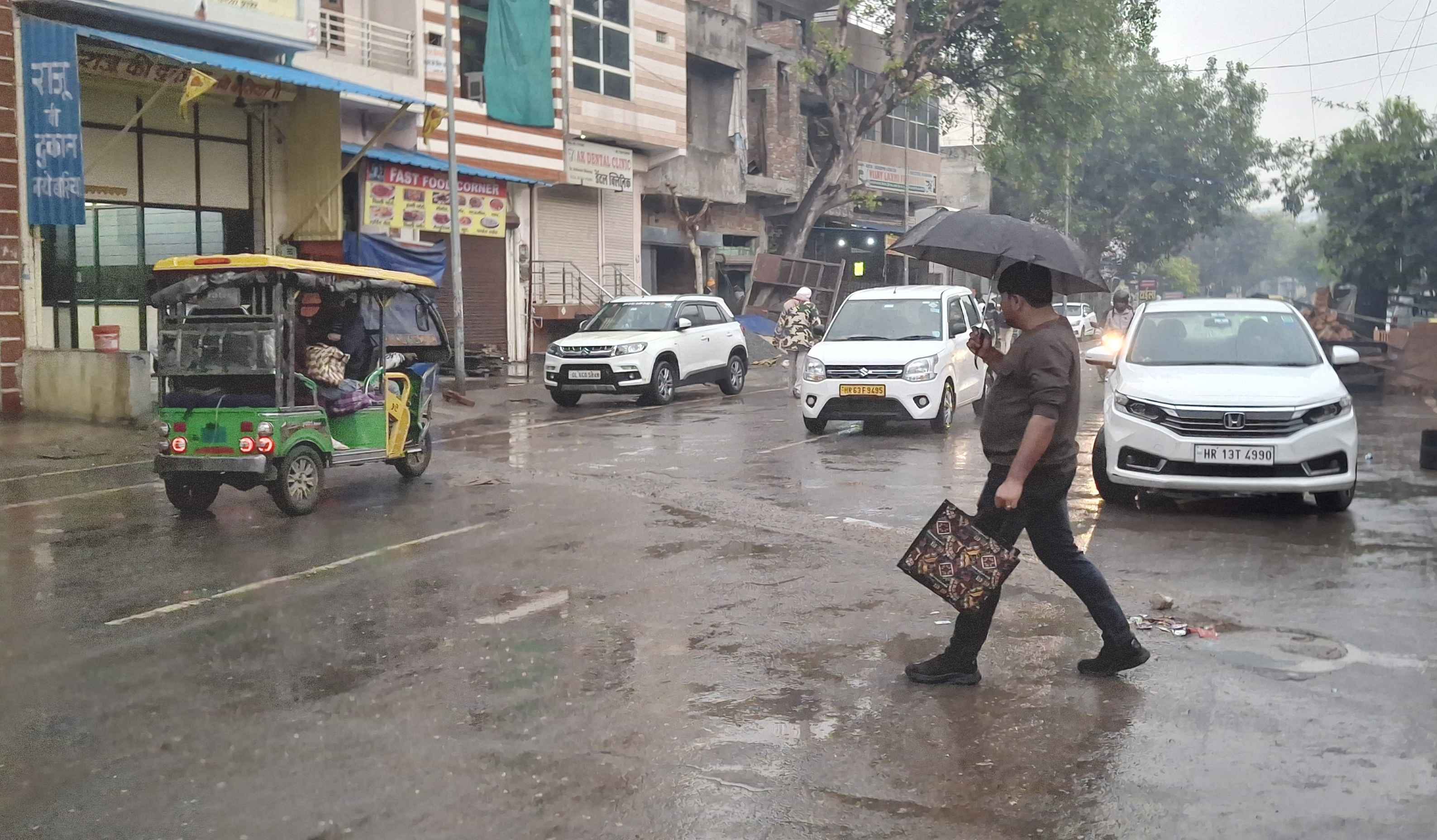 फोटो-52: बहादुरगढ़ के रेलवे रोड पर बारिश से बचने को छाता लिए जाती महिलाएं। संवाद फोटो-52: बहादुरगढ़ के रेलवे रोड पर बारिश से बचने को छाता लिए जाती महिलाएं। संवाद