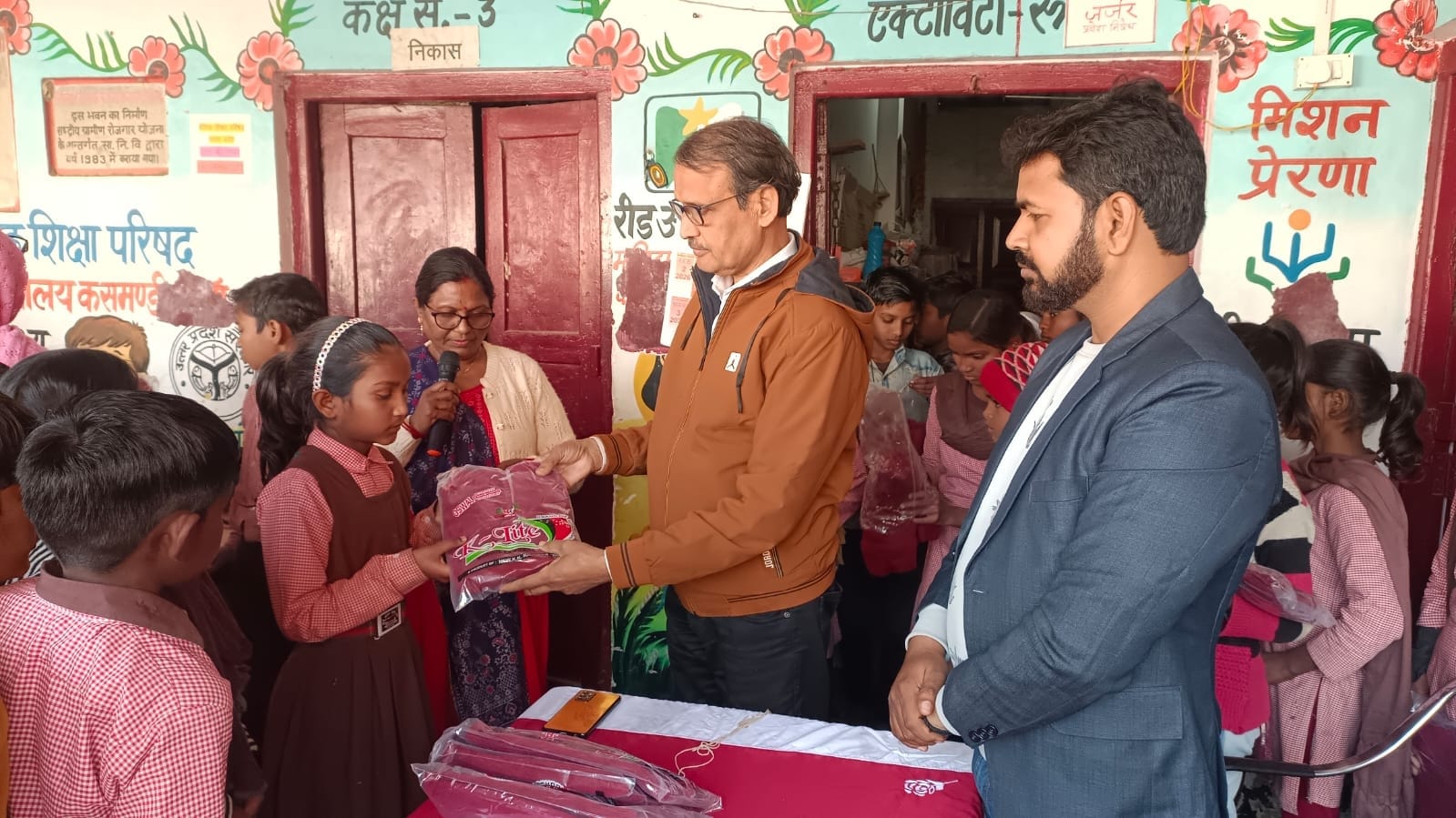 छात्र-छात्राओं को स्वेटर देते खंड शिक्षा अधिकारी।