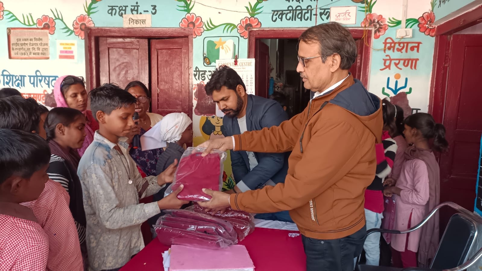 छात्र-छात्राओं को स्वेटर देते खंड शिक्षा अधिकारी।