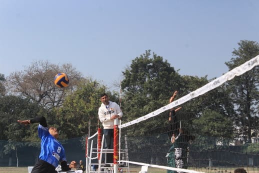 वालीबॉल प्रतियोगिता में बॉल को स्मैश मारने का प्रयास करती महिला खिलाड़ी। संवाद