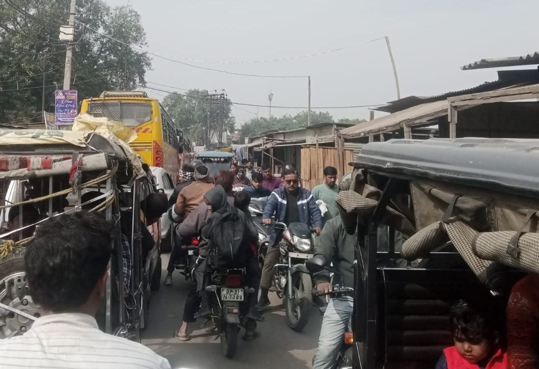 मेला मैदान चौराहे के पास बीच सड़क पर बस रोककर सवारियों को चढाते-उतारते हुए।