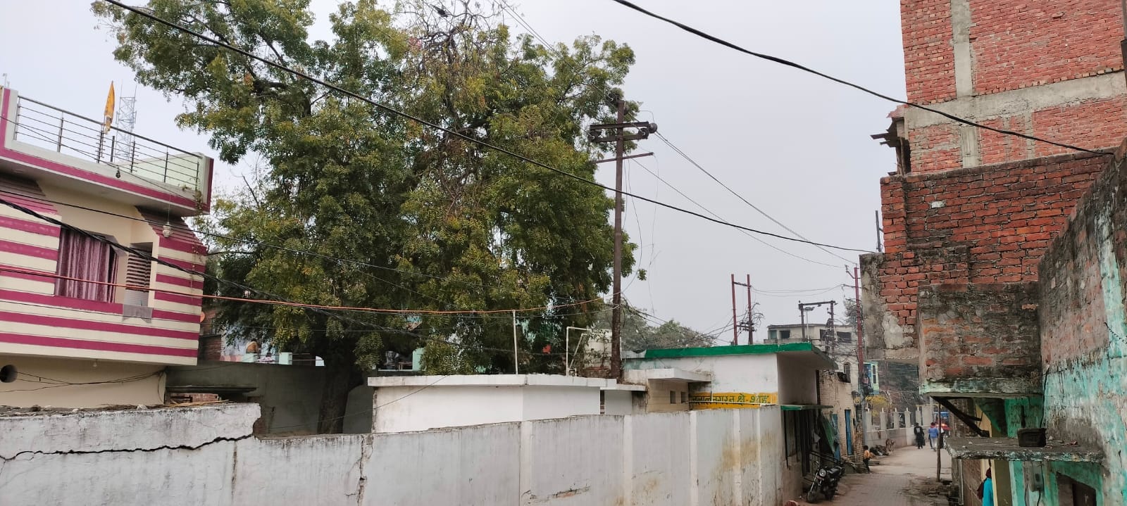 प्राथमिक विद्यालय तारीन जलालनगर के अंदर लगा बिजली का खंभा और खड़े बच्चे। संवाद